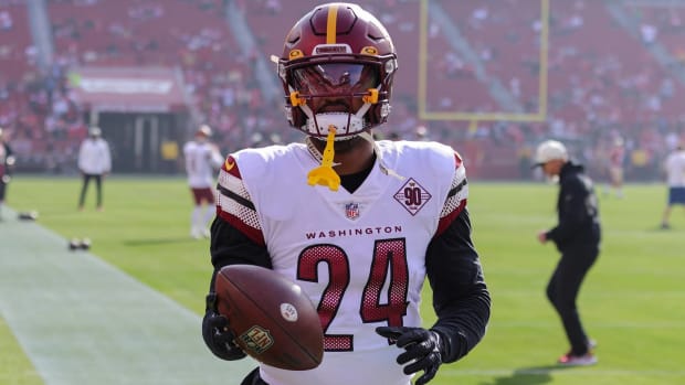 Commanders running back Antonio Gibson catches a ball while warming up before a game.